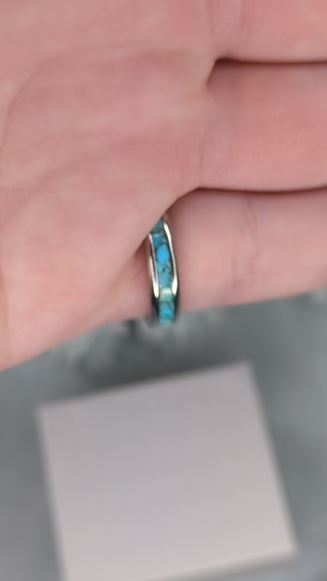 Raw natural blue Kingman turquoise in a stainless steel inlay ring channel. The ring is on a finger and rotated in the video to show the shine.
